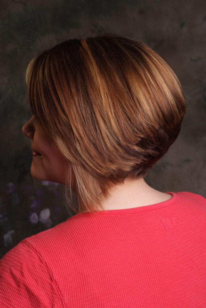 Sleek bob with warm highlights, styled at Olympia Salon